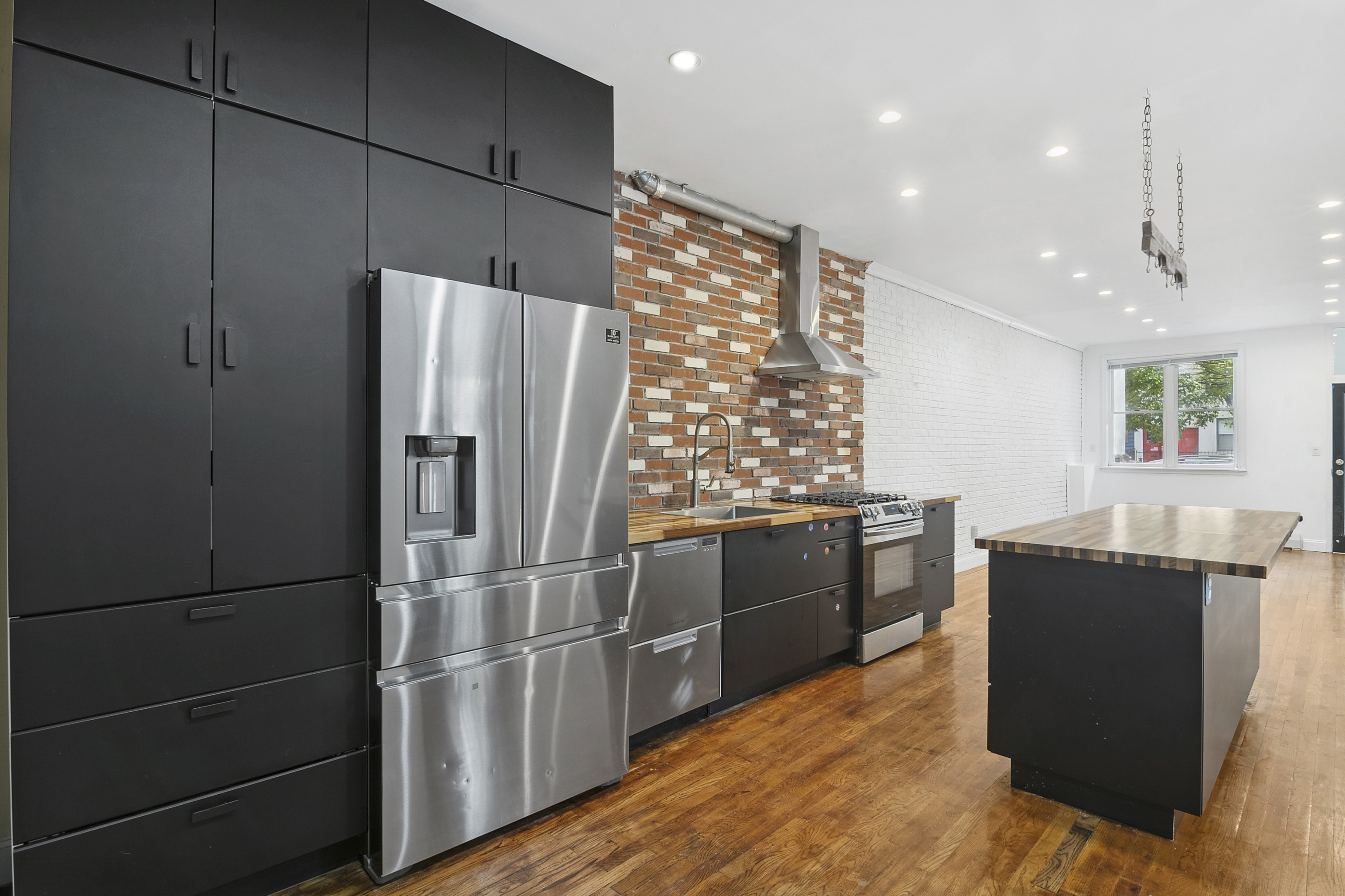 a kitchen with granite countertop a refrigerator and a stove top oven