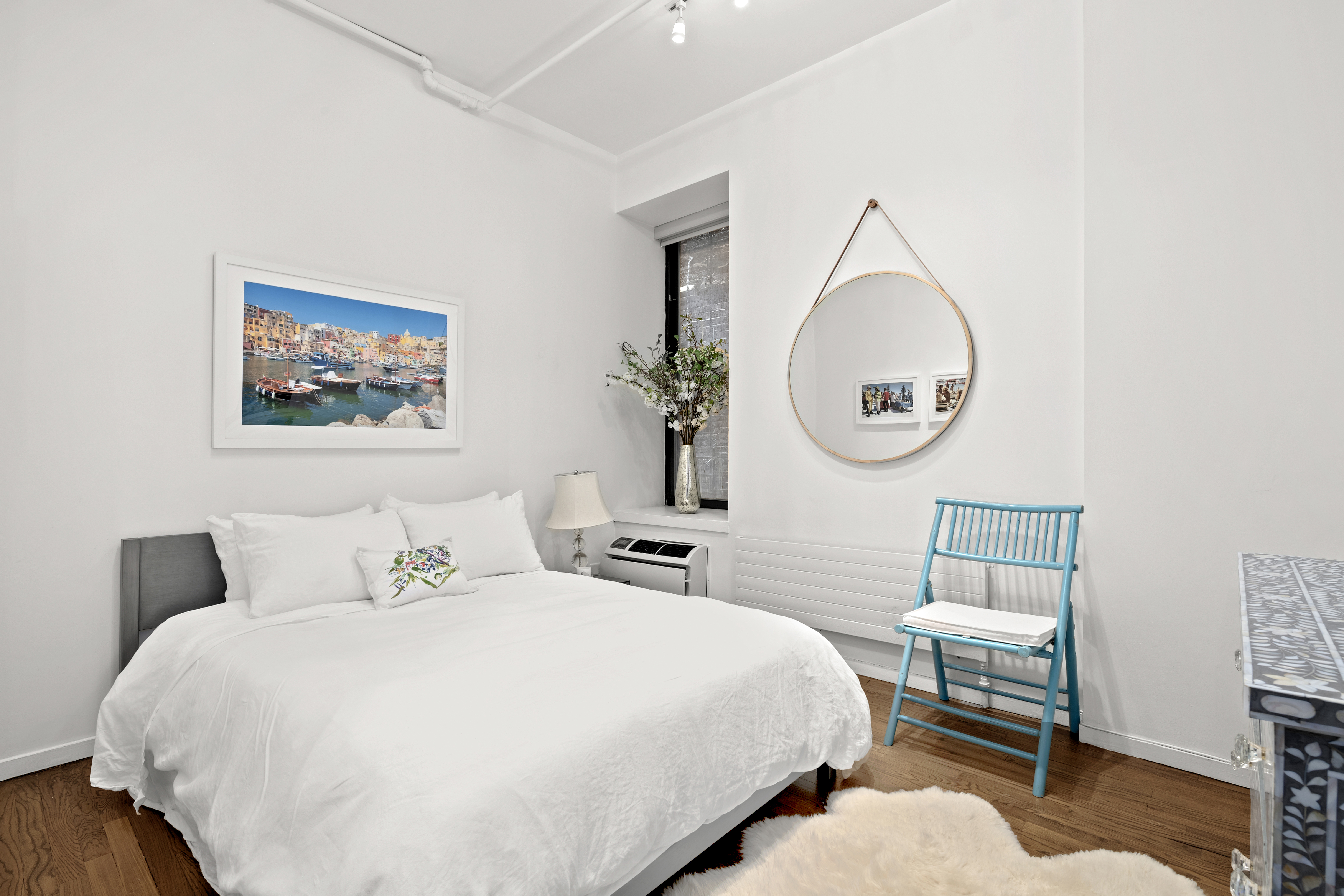 120 West 18th Street, Unit 2A Manhattan, NY 10011 - Photo 11 of 14 a bedroom with a bed a mirror and a potted plant