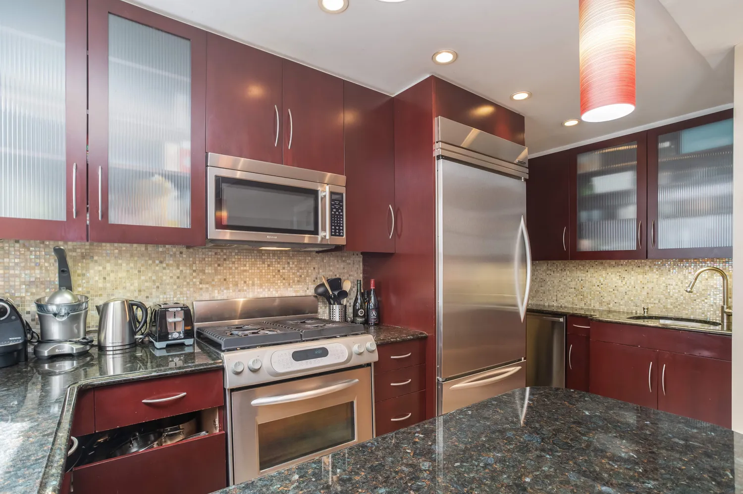 a kitchen with stainless steel appliances granite countertop a refrigerator stove and sink