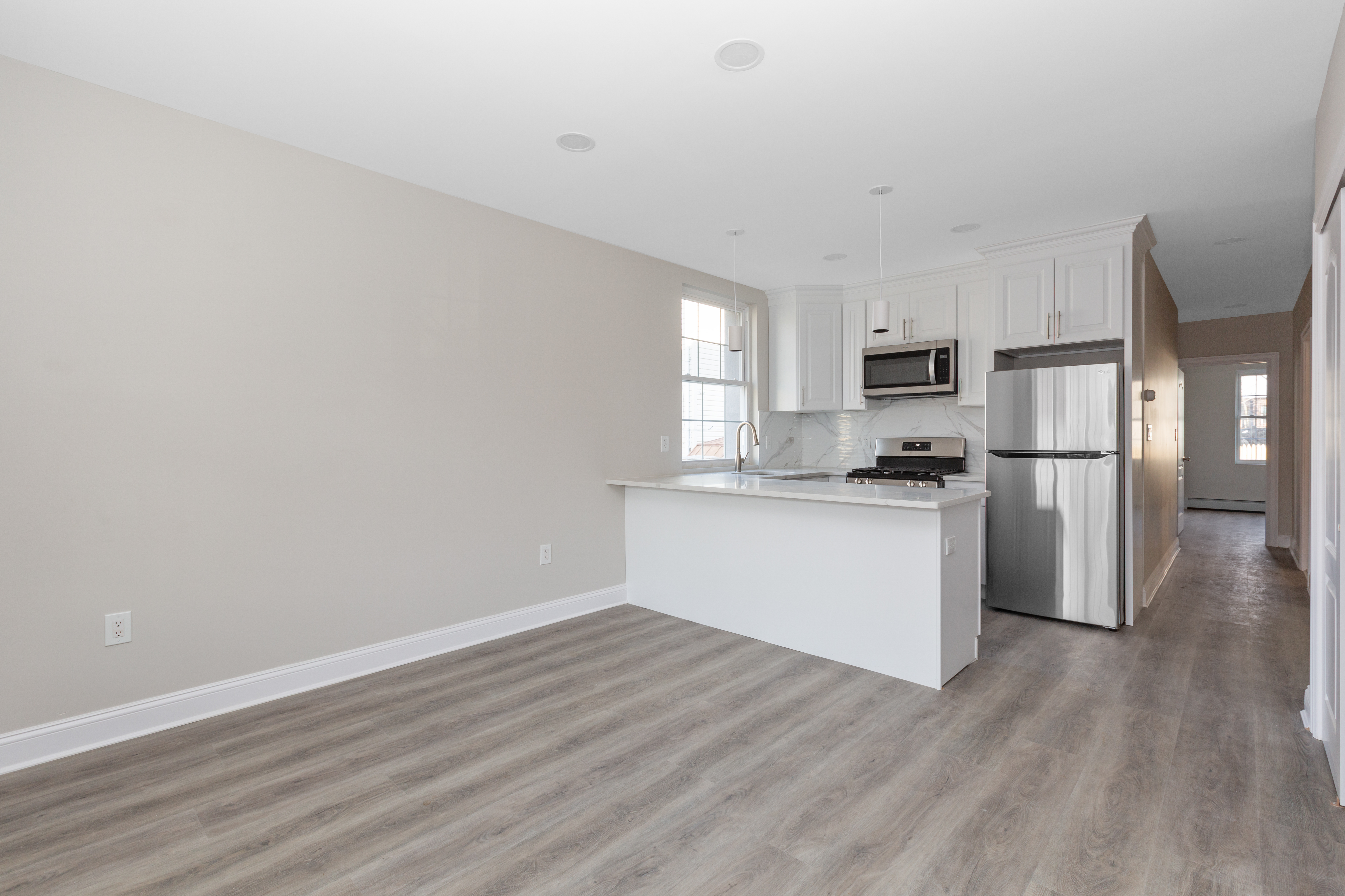 143-10 Shore Avenue Queens, NY 11435 - Photo 17 of 30 a kitchen with wooden floors white appliances and cabinets