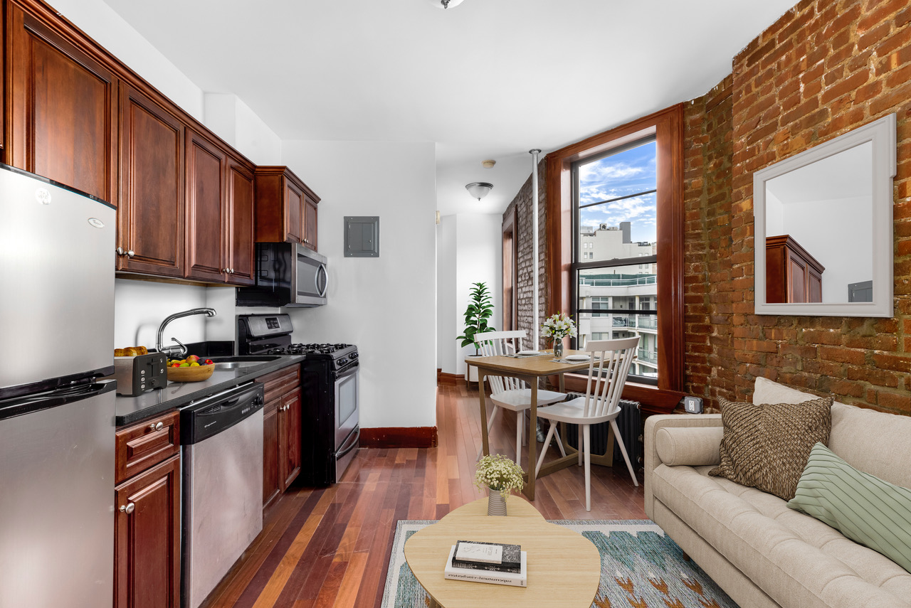 a kitchen with stainless steel appliances granite countertop a stove a refrigerator a sink a dining table and chairs with wooden floor