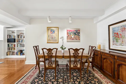 a view of a dining room with furniture a rug and wooden floor
