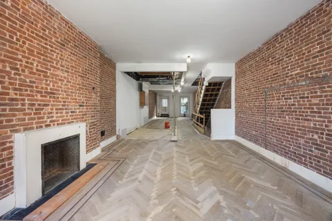 a view of a livingroom with stairs and a fireplace