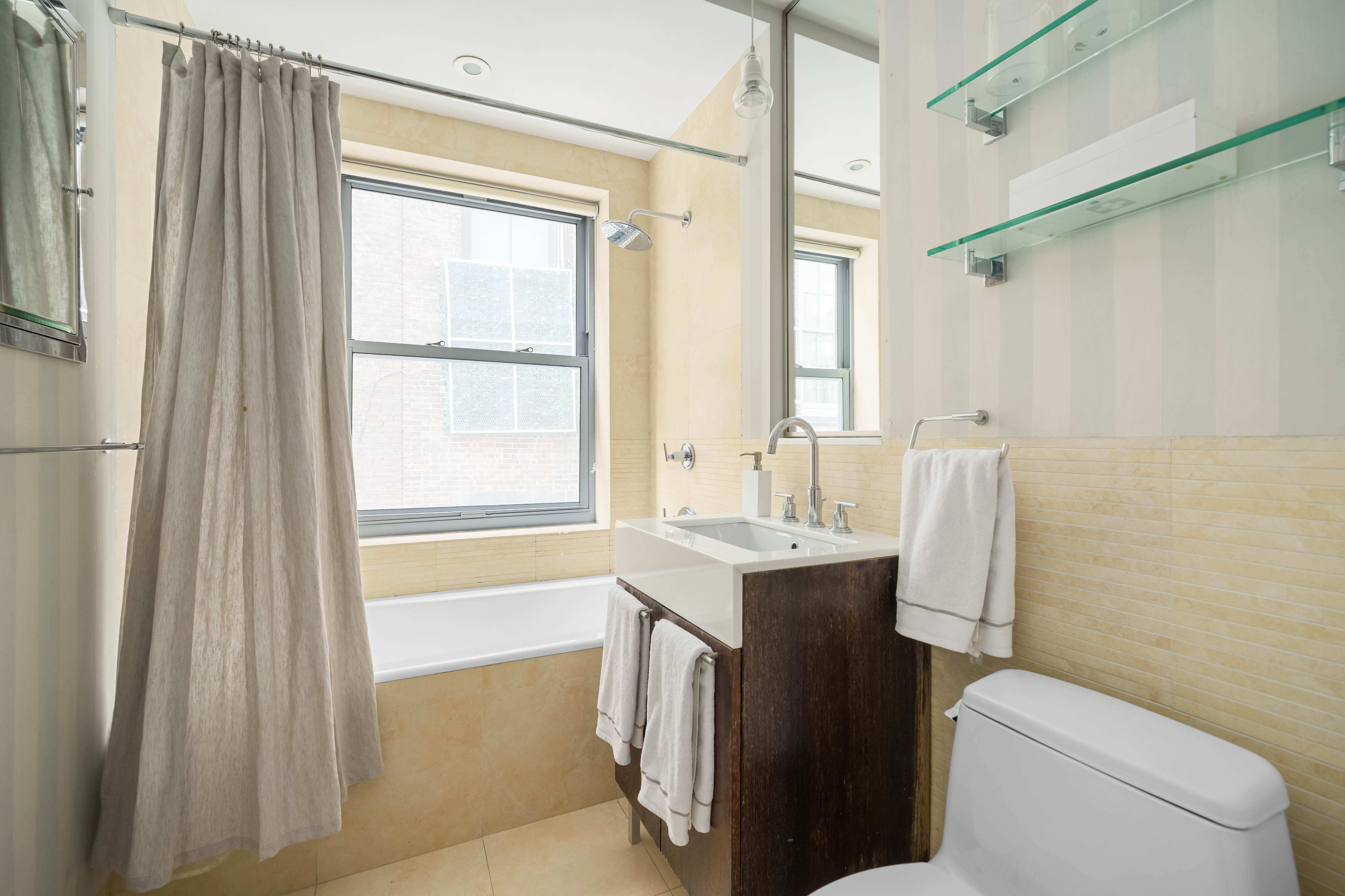 92 Greene Street, Unit 3B Manhattan, NY 10012 - Photo 7 of 8 a bathroom with a sink a toilet and a bathtub