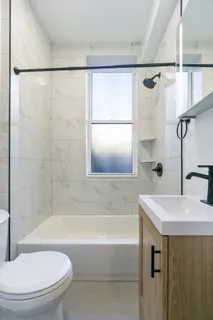 a bathroom with a sink mirror toilet and bathtub