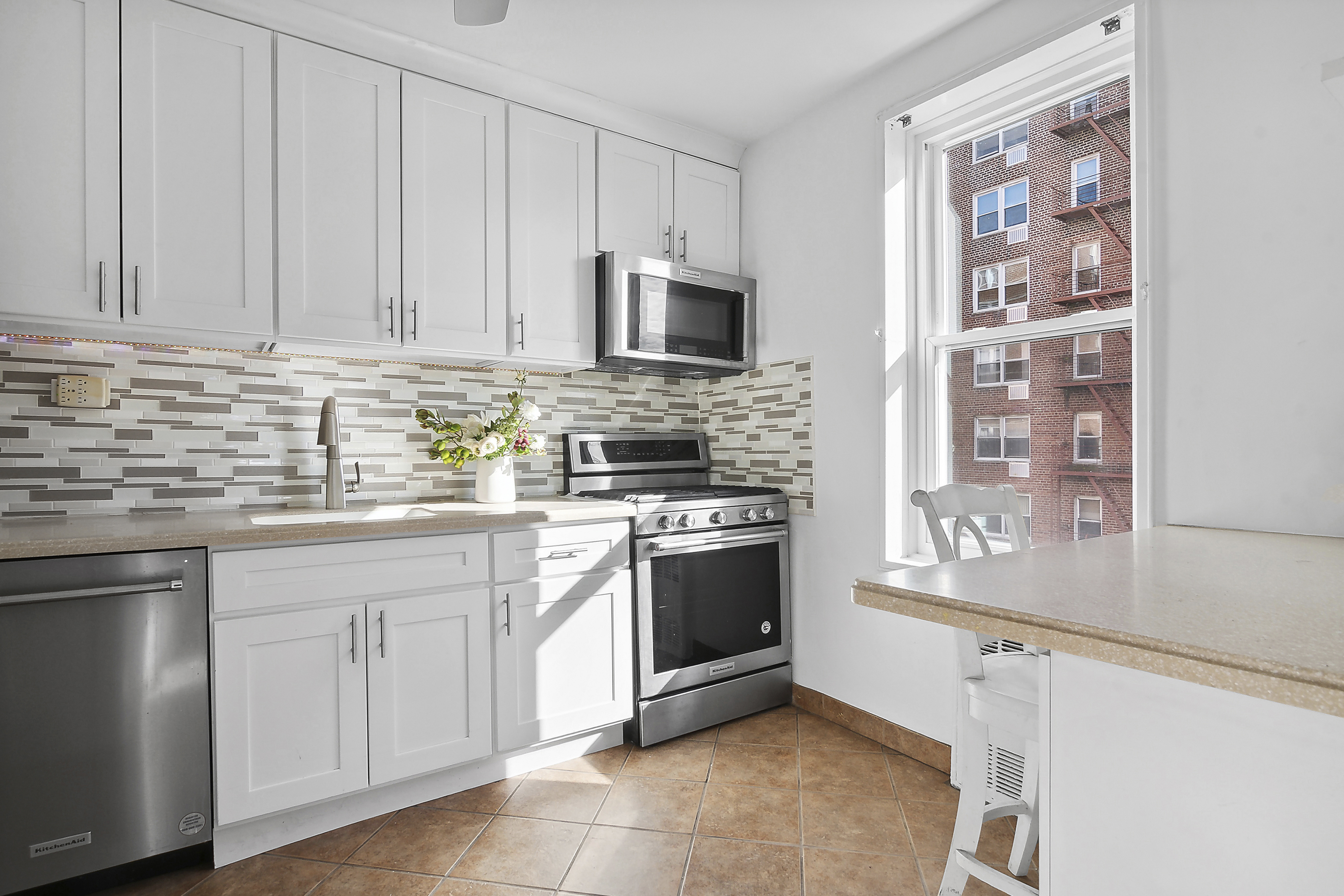 9201 Shore Road, Unit B301 Brooklyn, NY 11209 - Photo 6 of 12 a kitchen with stainless steel appliances granite countertop a stove a sink and a microwave