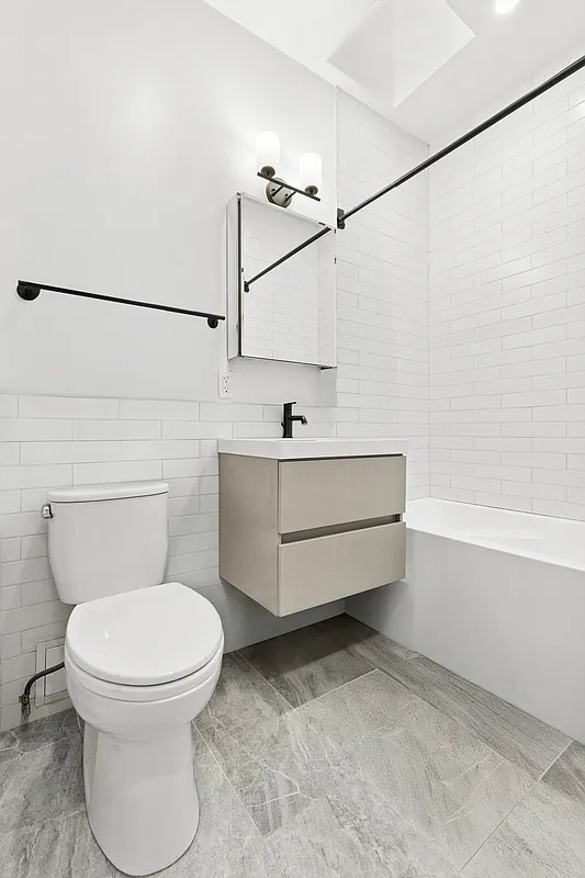204 Smith Street, Unit 3R Brooklyn, NY 11201 - Photo 5 of 7 a bathroom with a sink mirror vanity and toilet