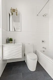 a bathroom with a white toilet sitting next to a bathtub