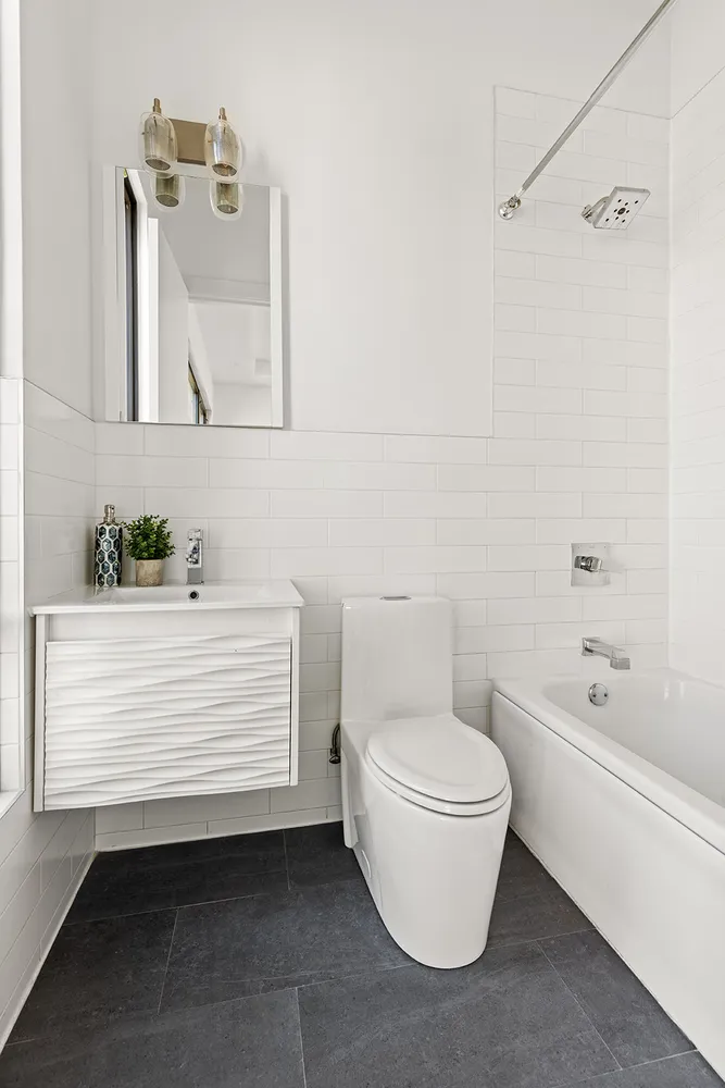 a bathroom with a white toilet sitting next to a bathtub