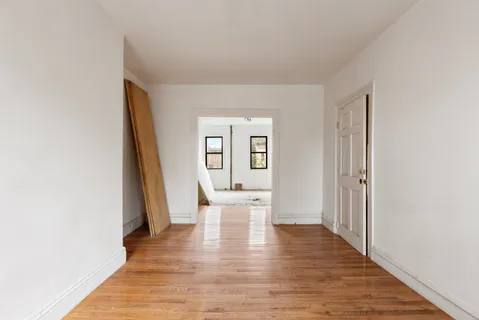 a view of a room with wooden floor and a window