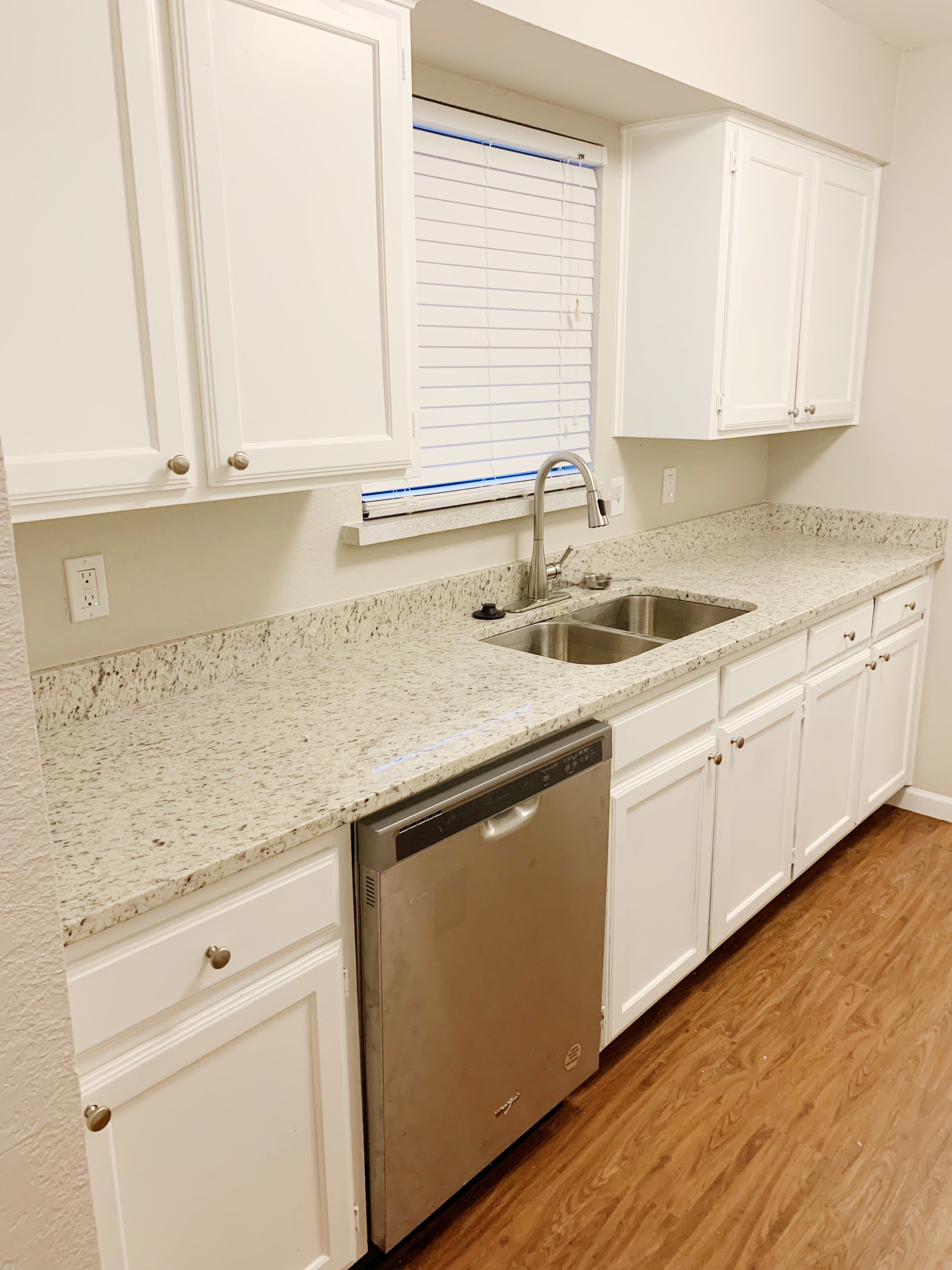 a kitchen with granite countertop white cabinets and white appliances