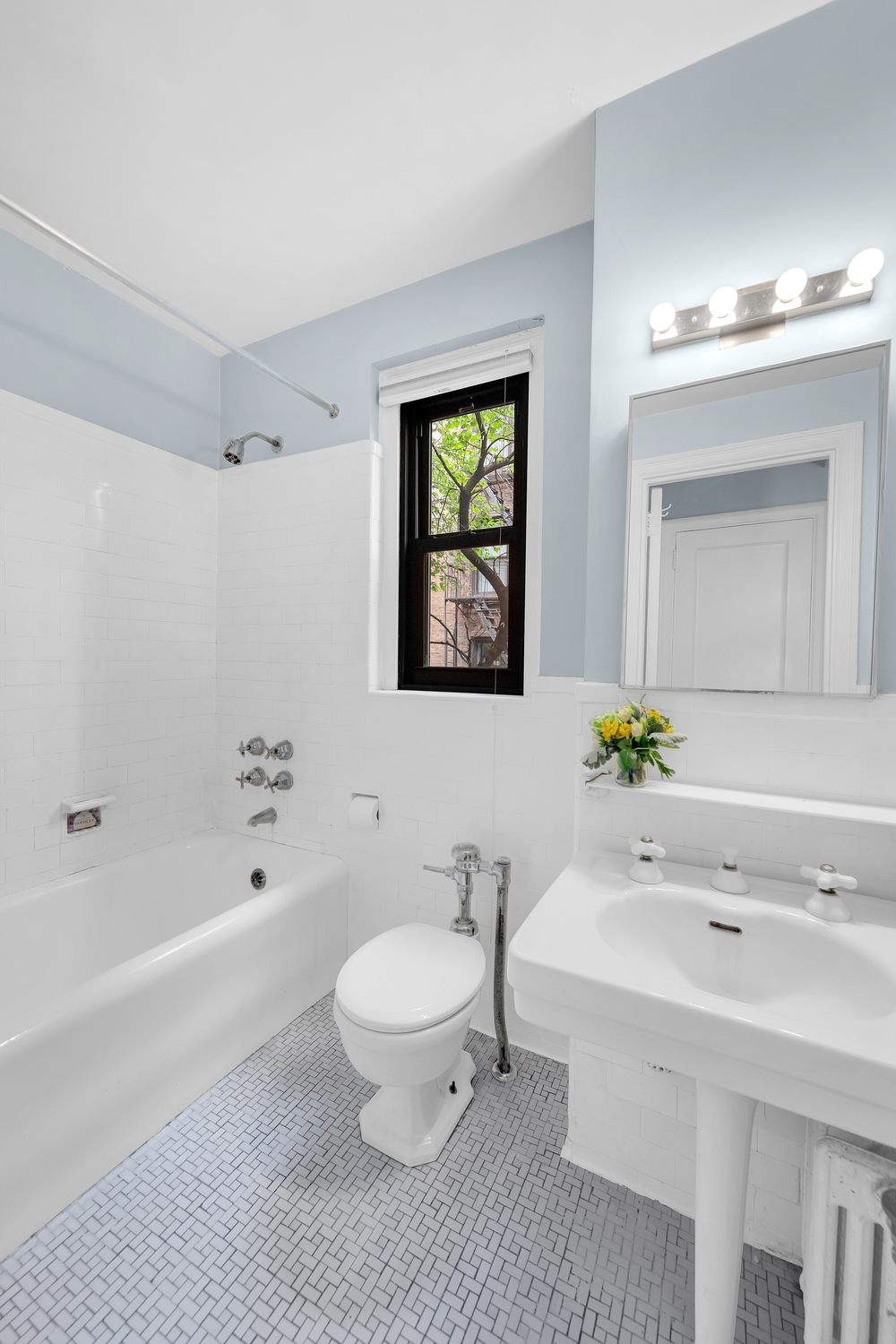 151 East 83rd Street, Unit 2E Manhattan, NY 10028 - Photo 5 of 12 a bathroom with a sink a toilet and shower