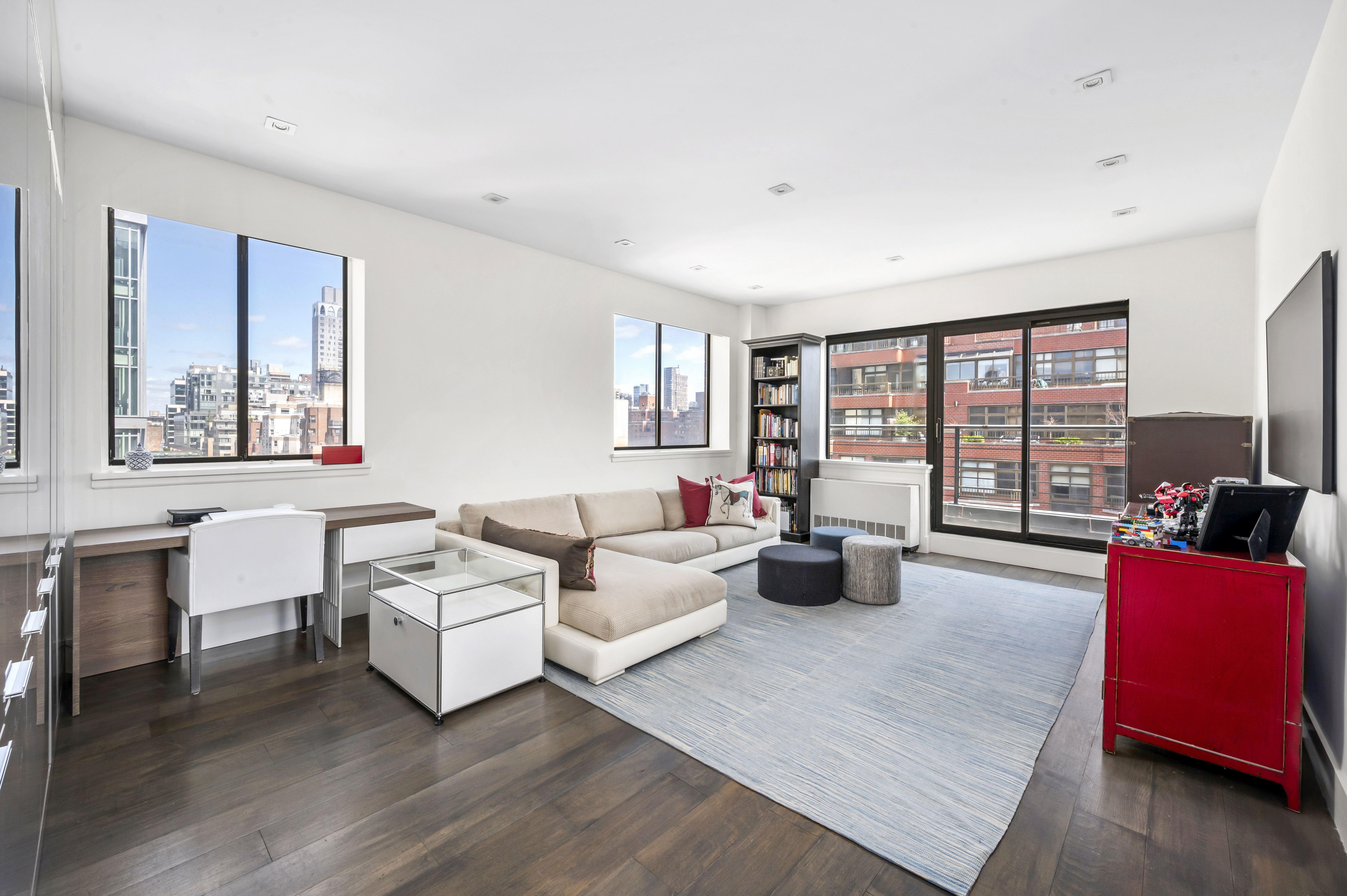 131 East 81st Street, Unit PH15 Manhattan, NY 10028 - Photo 2 of 11 a living room with furniture and a large window