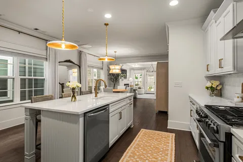 a kitchen with stainless steel appliances a sink stove and cabinets
