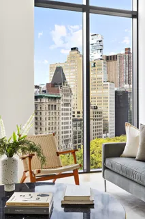 a living room with furniture and a floor to ceiling window