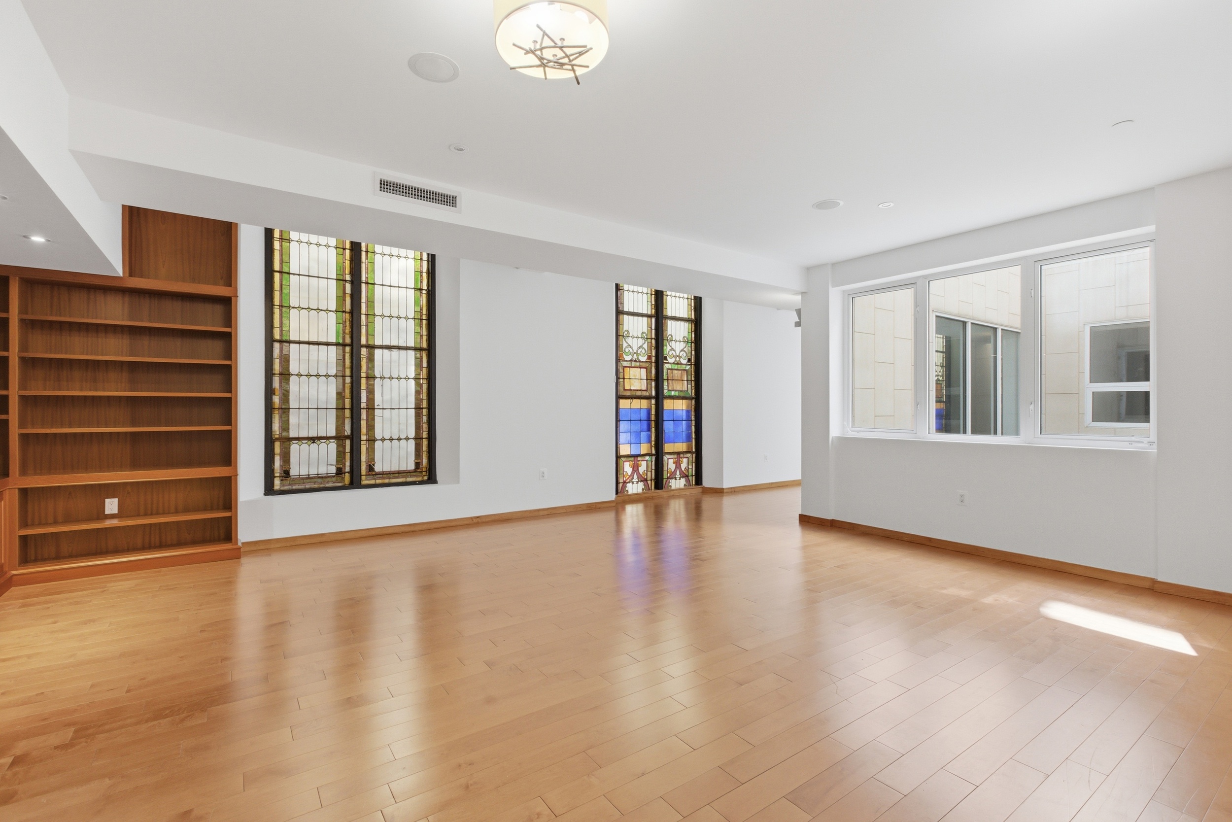 135 West 4th Street, Unit 3W Manhattan, NY 10012 - Photo 4 of 24 a view of an empty room with a window and wooden floor