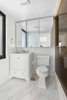 a bathroom with a sink toilet and a mirror