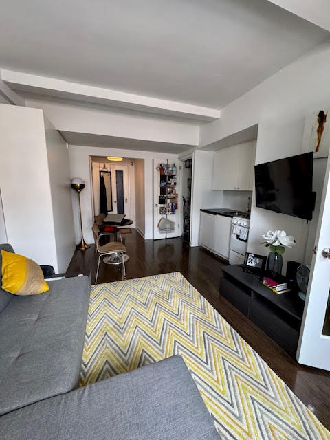 457 West 57th Street, Unit 1712 Manhattan, NY 10019 - Photo 2 of 9 a living room with furniture and a flat screen tv