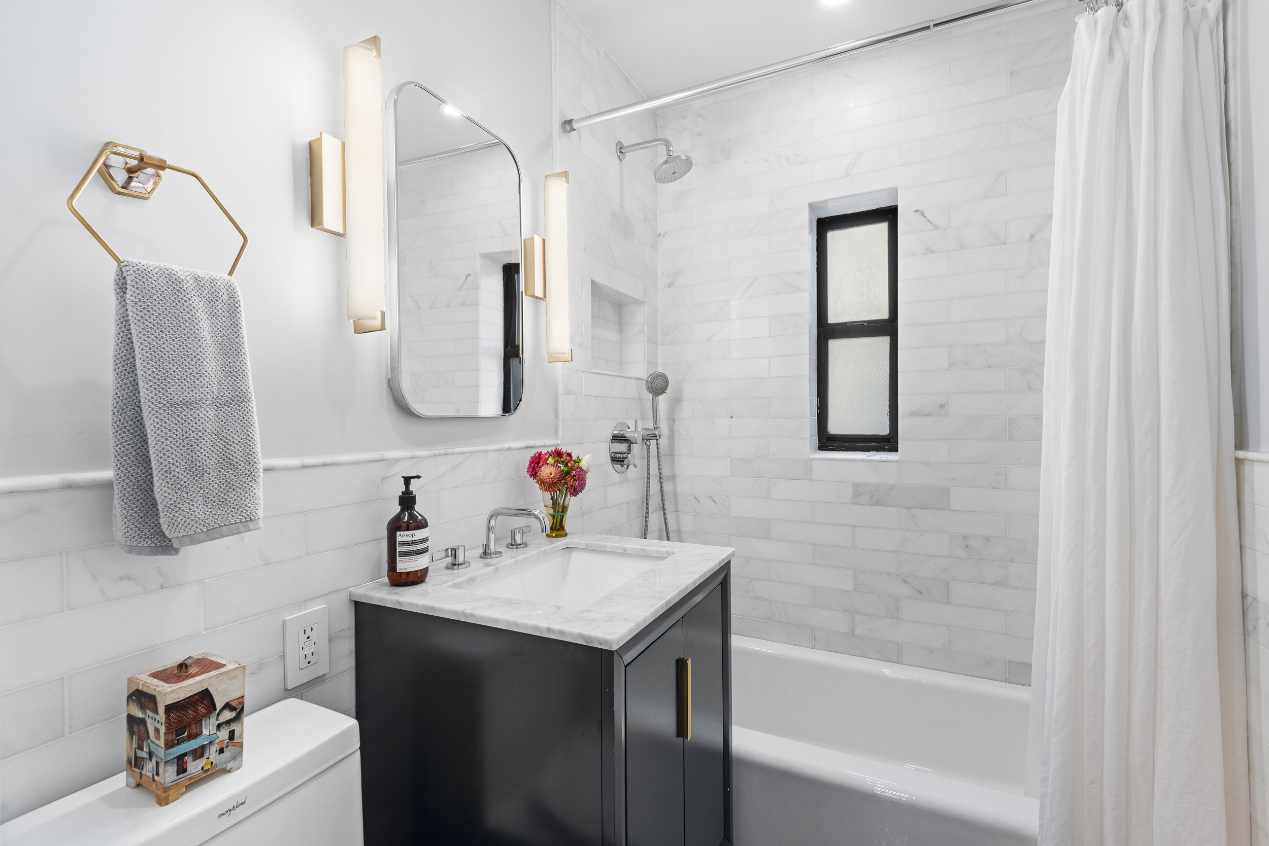 319 West 18th Street, Unit 5I Manhattan, NY 10011 - Photo 9 of 18 a bathroom with a sink vanity tub and a mirror