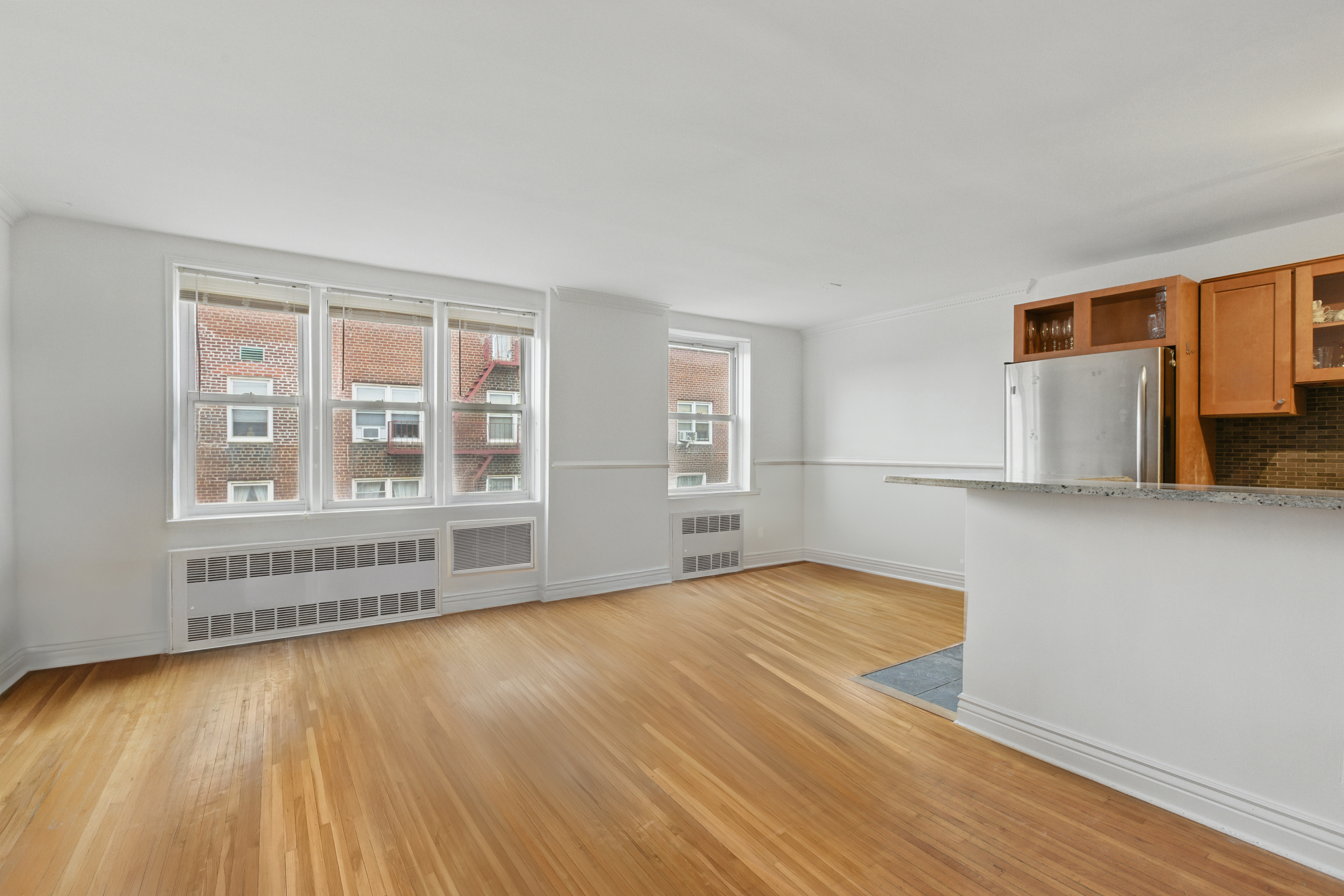 400 East 17th Street, Unit 711 Brooklyn, NY 11226 - Photo 4 of 12 wooden floor in an empty room with a window