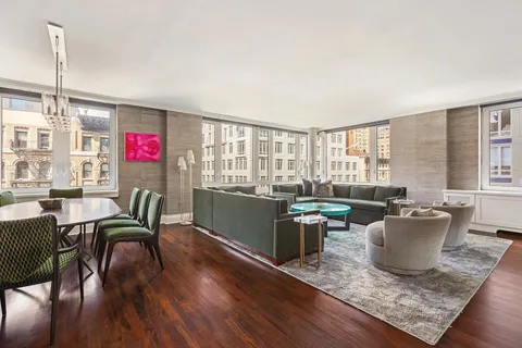 a dining room with wooden floor a chandelier a glass table and chairs