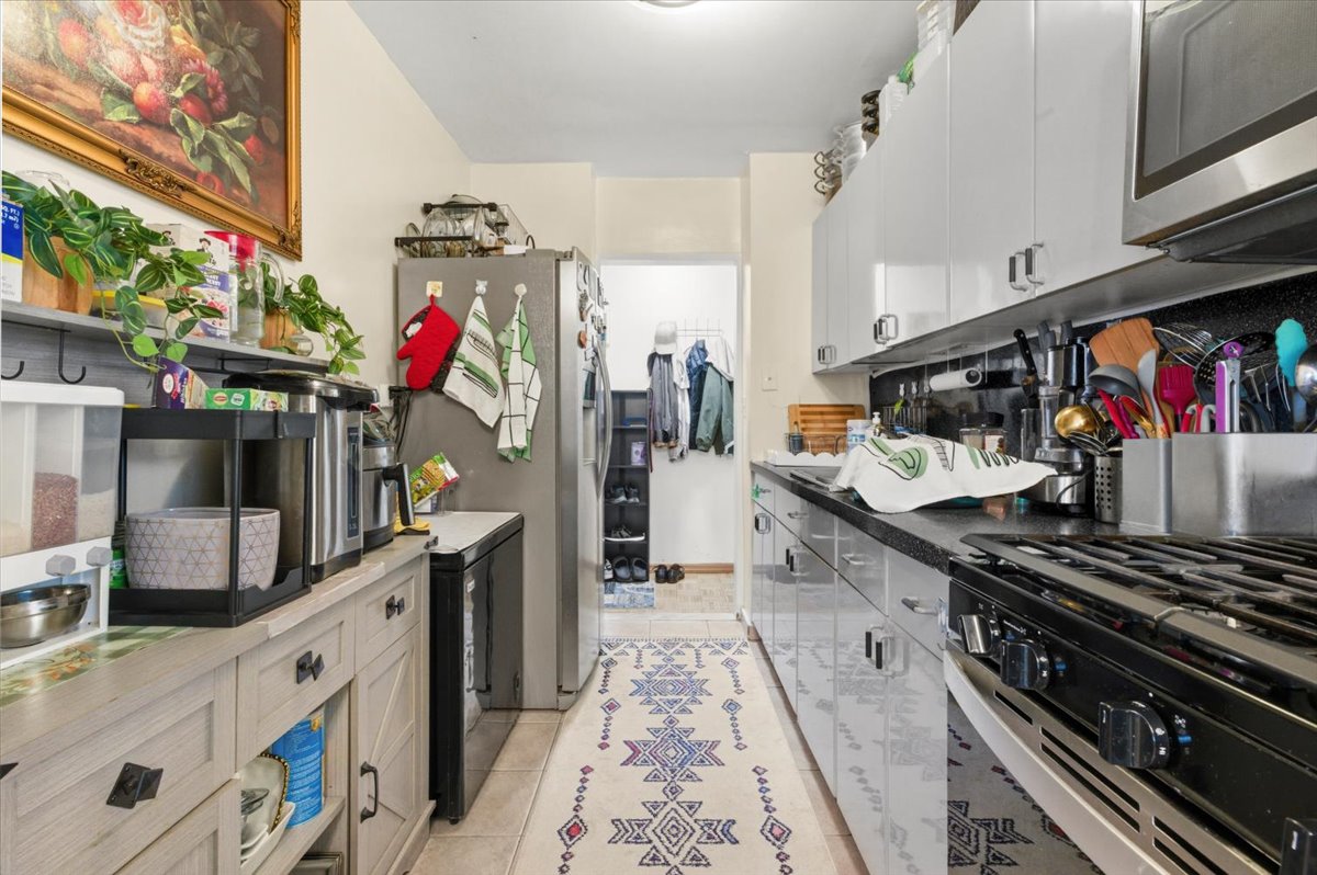 448 Neptune Avenue, Unit 14J Brooklyn, NY 11224 - Photo 5 of 21 a kitchen with stove top oven and cabinets