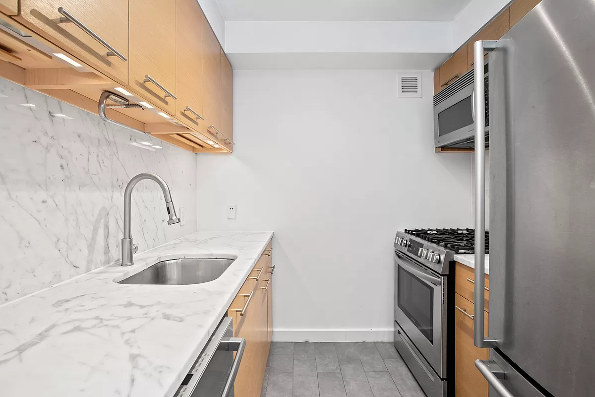 100 West 39th Street, Unit 37E Manhattan, NY 10018 - Photo 5 of 11 a kitchen with a sink and a stove top oven