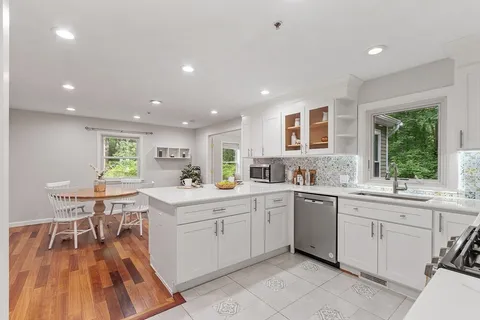 a kitchen with a sink dining table and chairs