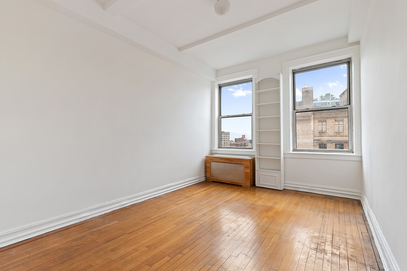 41 Eastern Parkway, Unit 8B Brooklyn, NY 11238 - Photo 11 of 13 an empty room with wooden floor and windows