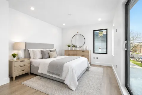 a bedroom with a large bed and wooden floor