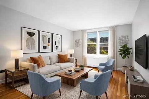 a living room with furniture flat screen tv and a large window