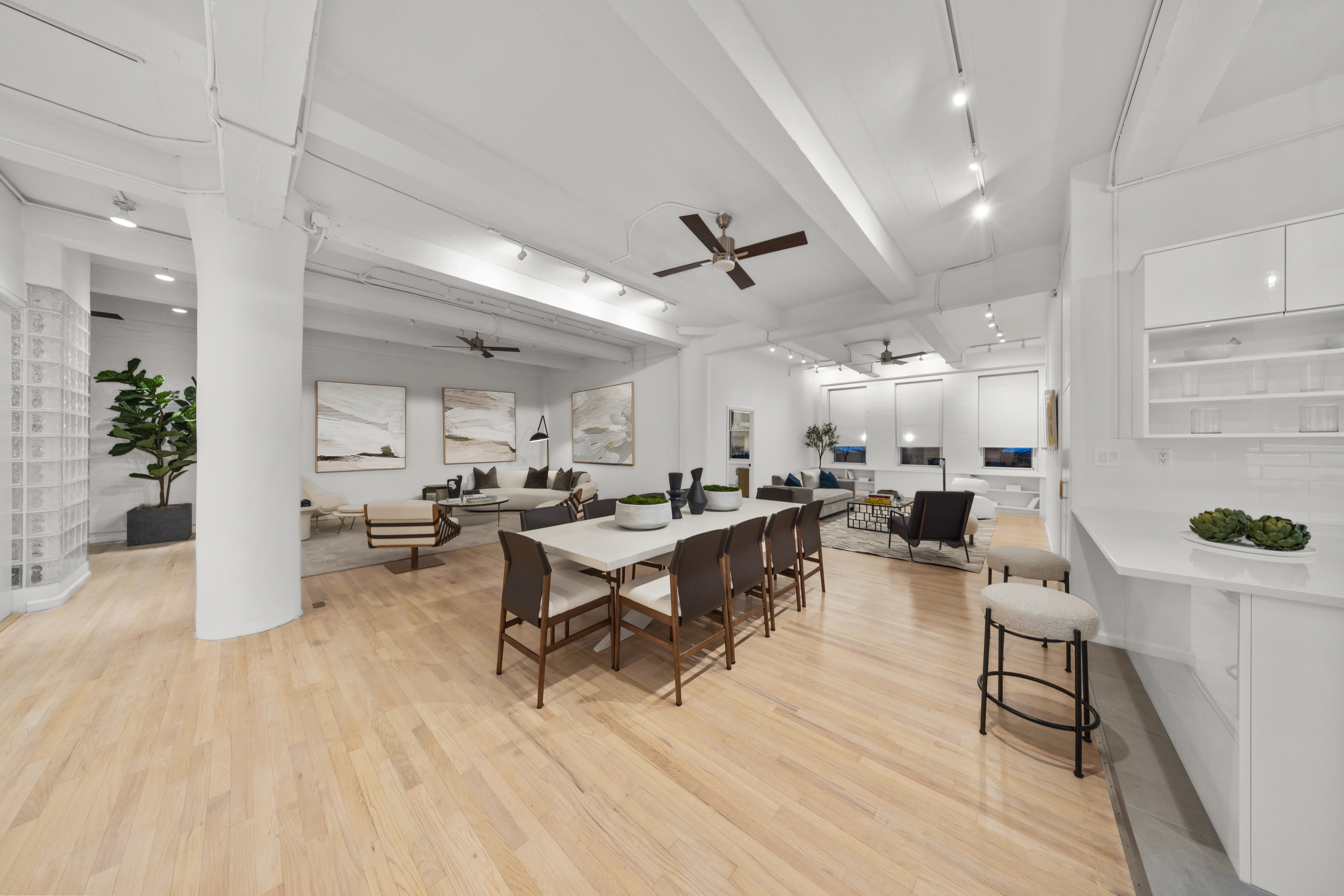 a living room with lots of furniture and view of kitchen