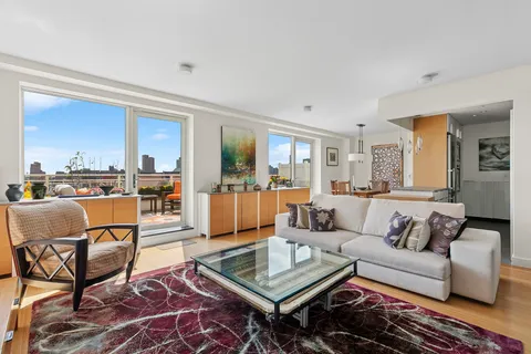 a living room with furniture and a view of kitchen