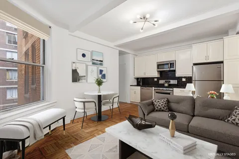 a living room with furniture a dining table and kitchen view
