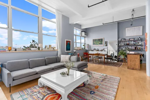 a living room with furniture wooden floor and a large window