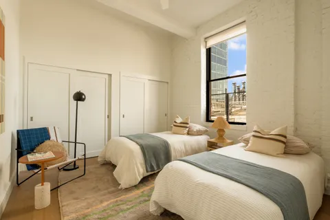 a bedroom with two beds and a potted plant