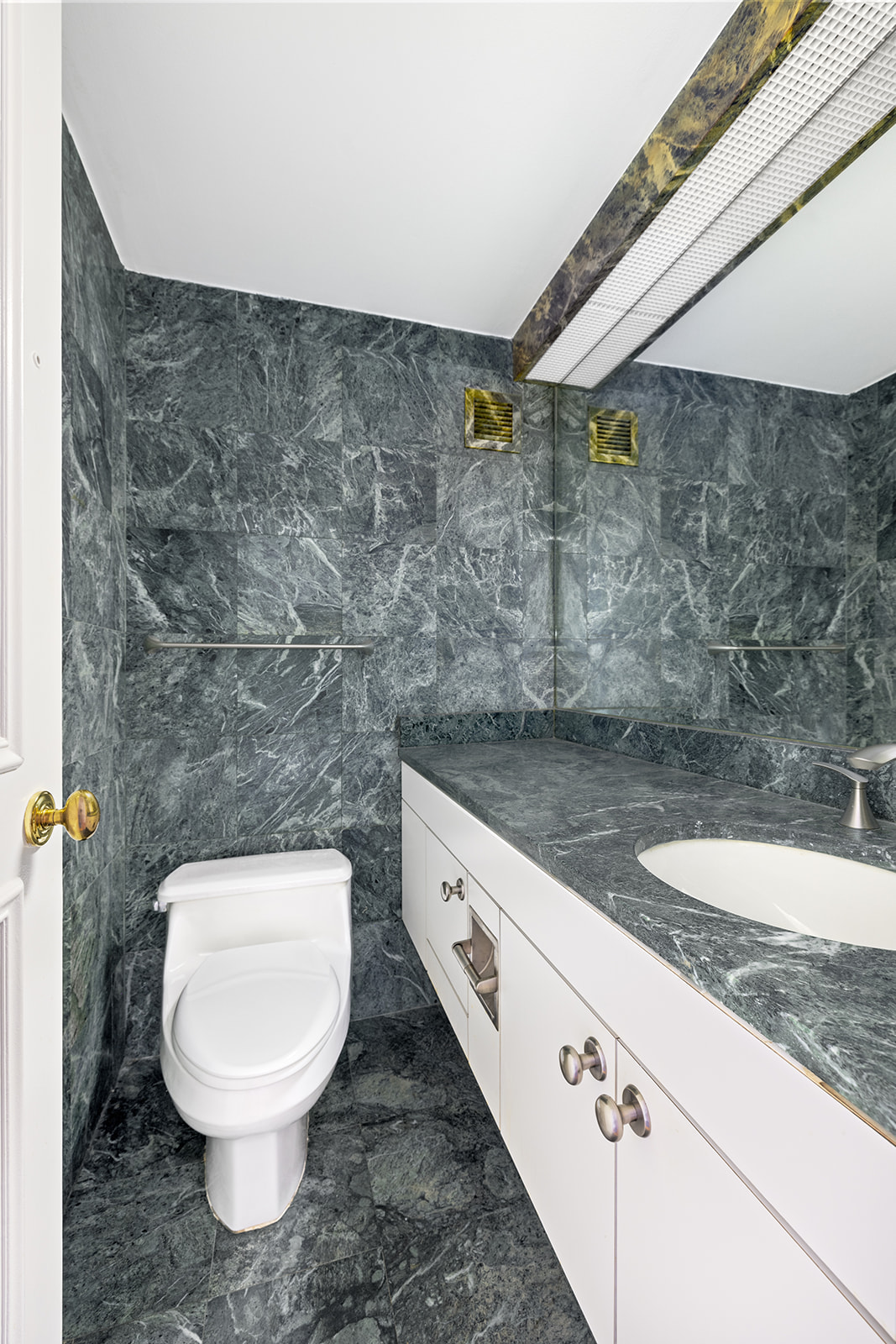 188 East 70th Street, Unit 8E Manhattan, NY 10021 - Photo 5 of 10 a bathroom with a granite countertop toilet and a sink