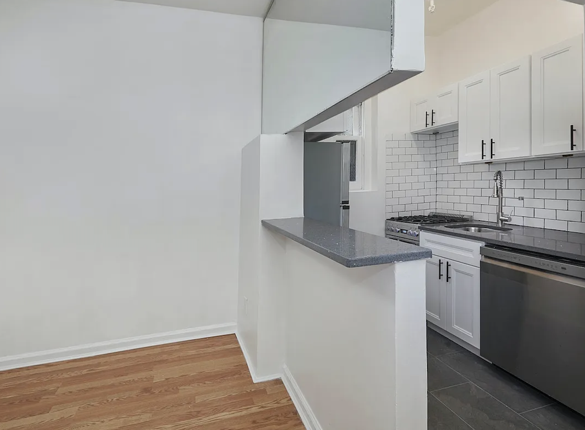 405 East 82nd Street, Unit 1B Manhattan, NY 10028 - Photo 4 of 10 a kitchen with stainless steel appliances granite countertop a sink and a stove
