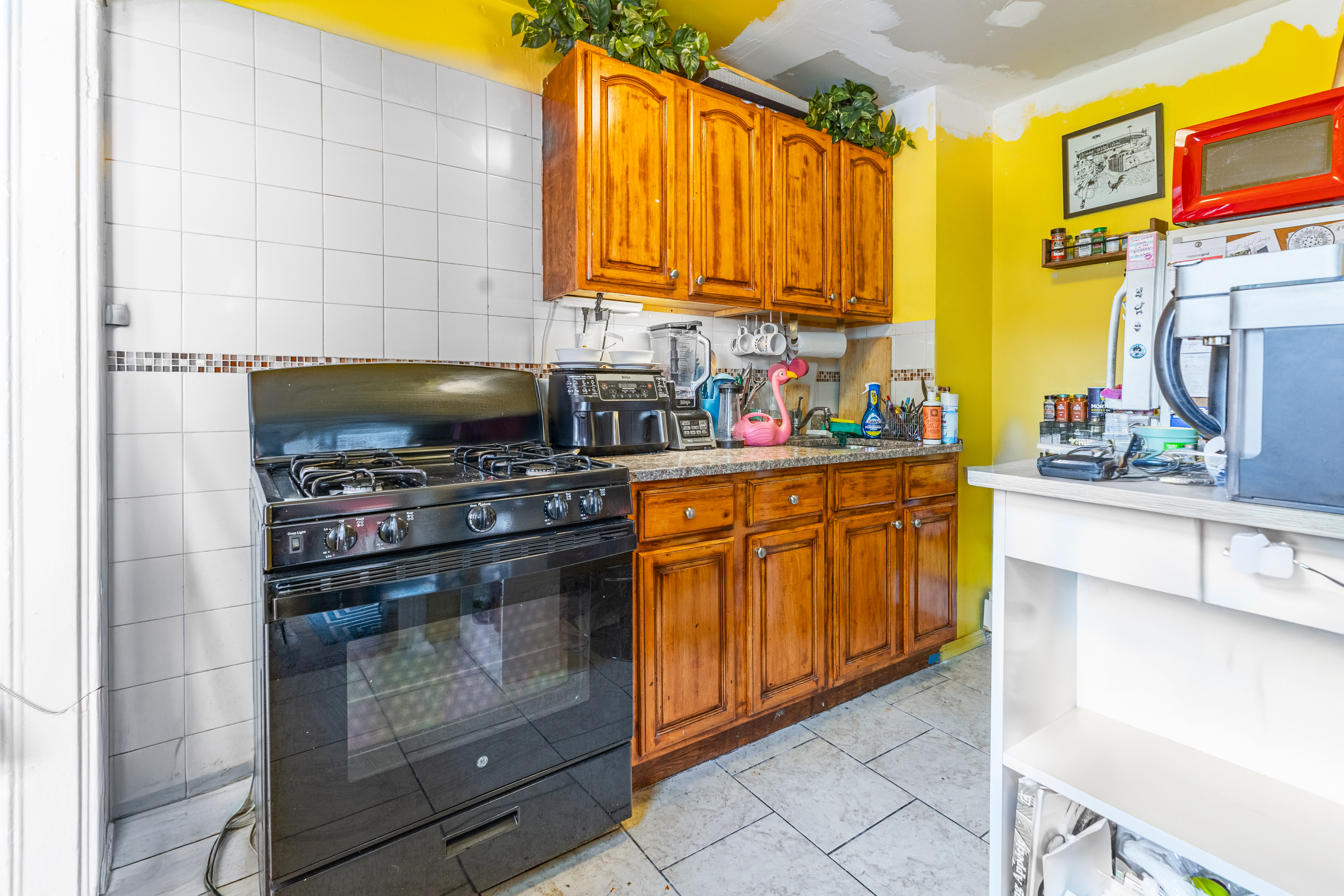 52 Himrod Street Brooklyn, NY 11221 - Photo 14 of 16 a kitchen with stainless steel appliances a stove a microwave and cabinets