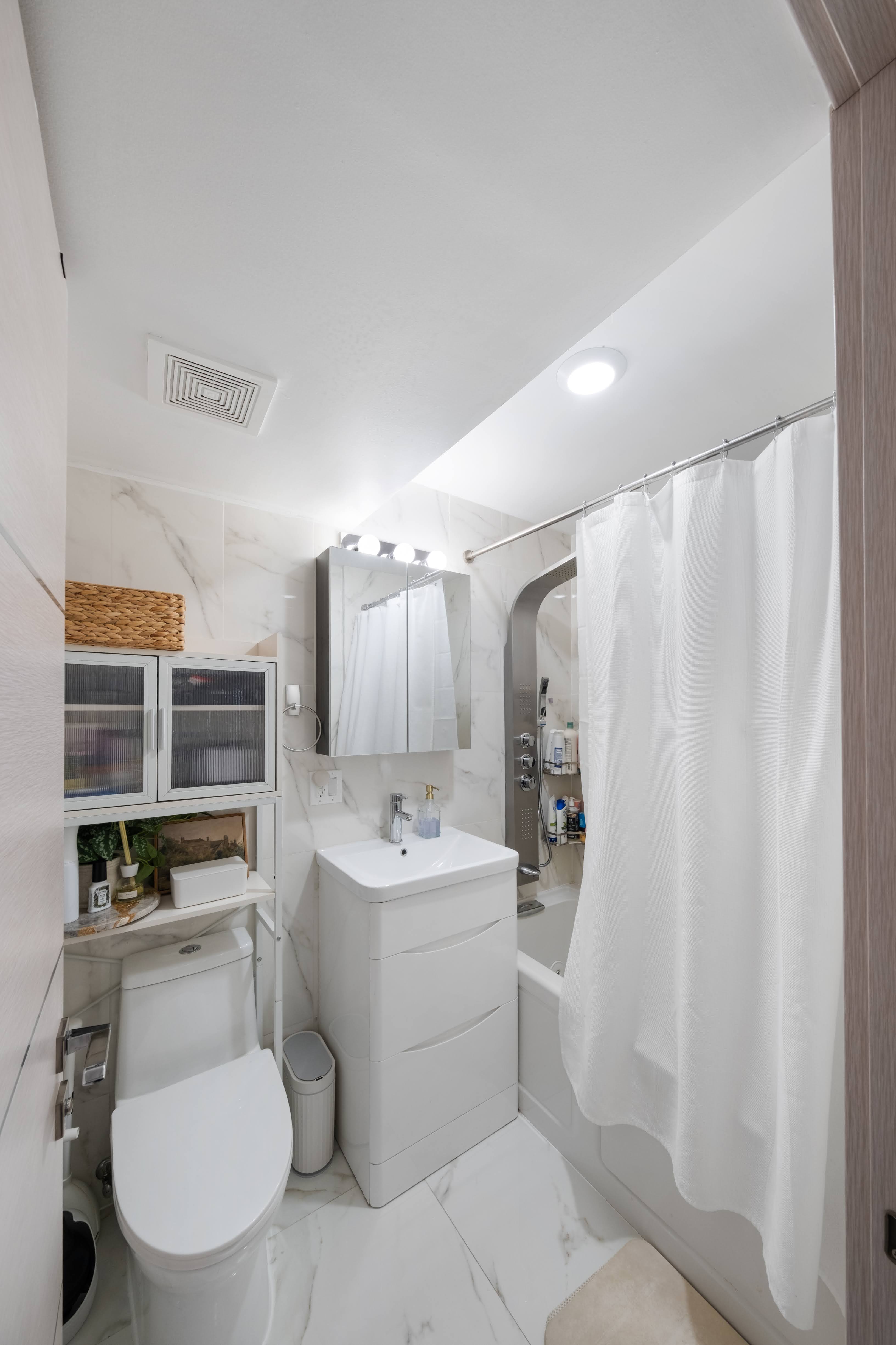 2025 Ocean Avenue, Unit 1B Brooklyn, NY 11230 - Photo 5 of 10 a bathroom with a sink toilet vanity and tub