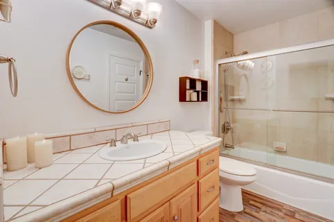 a bathroom with a sink a toilet and a mirror