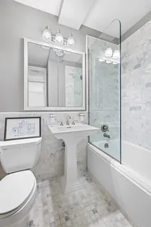 a bathroom with a sink toilet a mirror and bathtub