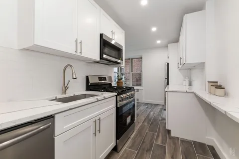 a kitchen with stainless steel appliances granite countertop a sink dishwasher stove top oven and refrigerator