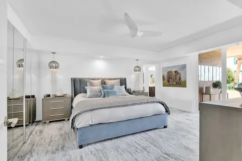 a spacious bedroom with a bed a table and painting on the wall