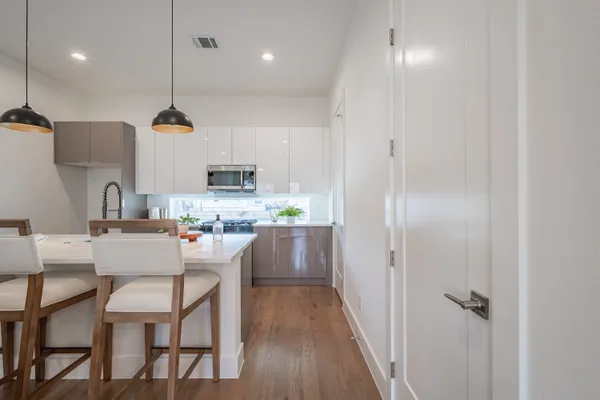 a kitchen with stainless steel appliances white cabinets and a stove top oven
