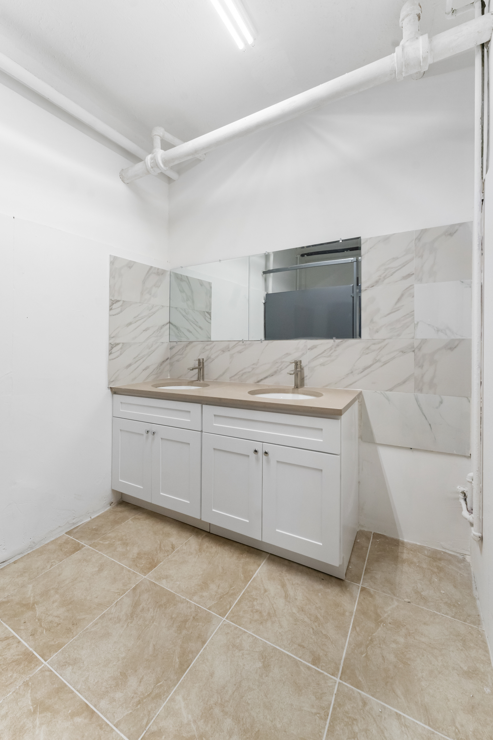 187 Maujer Street Brooklyn, NY 11206 - Photo 10 of 12 a bathroom with a granite countertop sink a mirror and a bathtub
