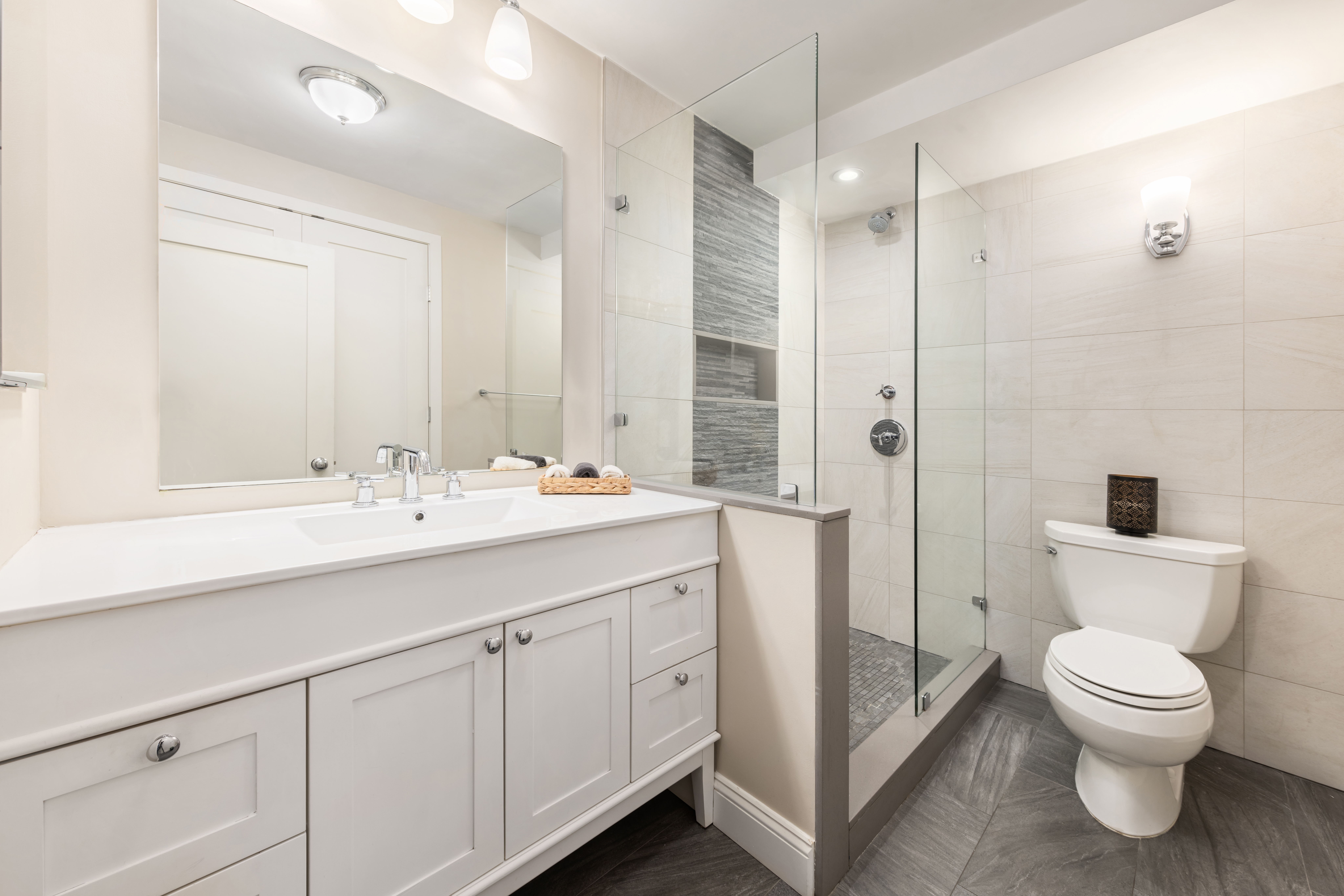 99 Reade Street, Unit 5E Manhattan, NY 10013 - Photo 8 of 13 a spacious bathroom with a double vanity sink toilet mirror and shower