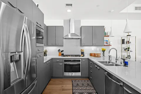 a kitchen with stainless steel appliances a refrigerator sink and wooden floor