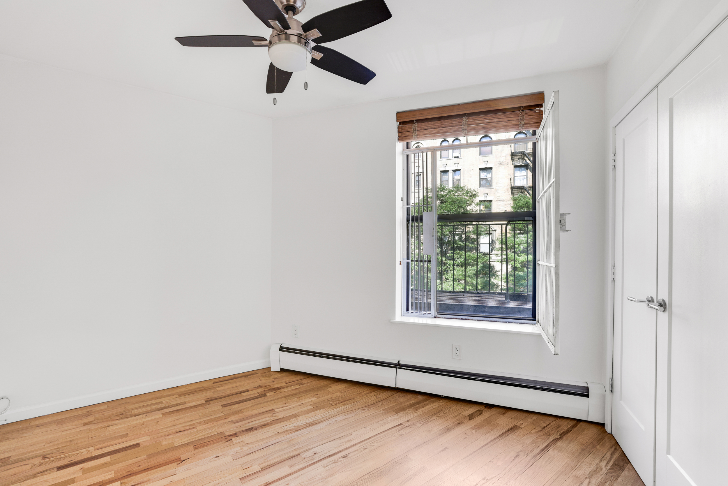66-72 St Nicholas Avenue, Unit 3G Manhattan, NY 10026 - Photo 10 of 15 a view of an empty room with wooden floor and a window