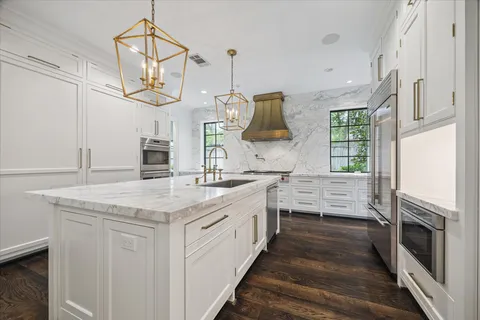 a kitchen with stainless steel appliances granite countertop a stove a sink and a refrigerator